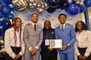 Group photo of Boys & Girls Clubs youth and staff holding a State Youth of the Year award at a celebration event.