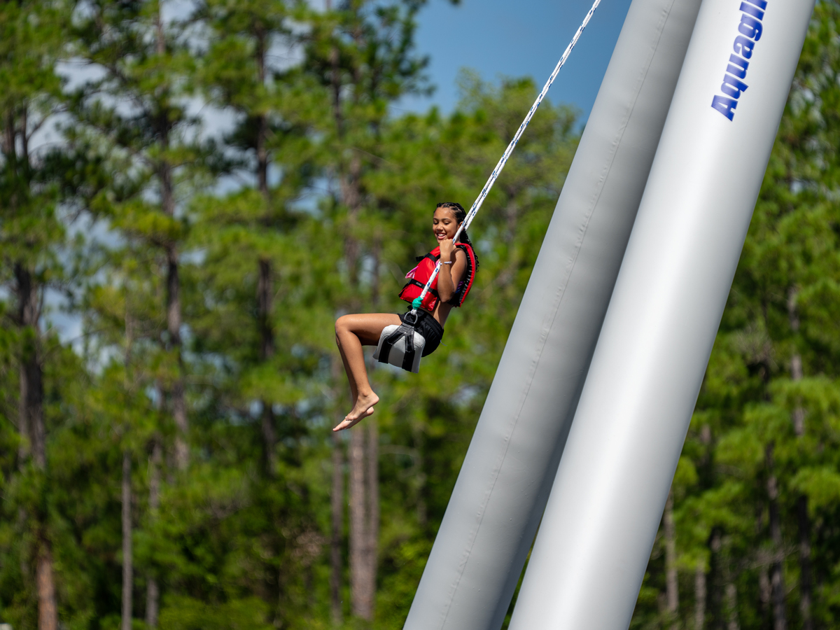 Camper on the rope swing at McKenzie's Camp Deep Pond