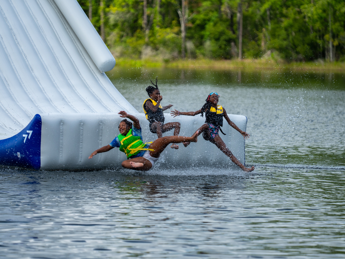 Campers on the water slide at McKenzie's Camp Deep Pond
