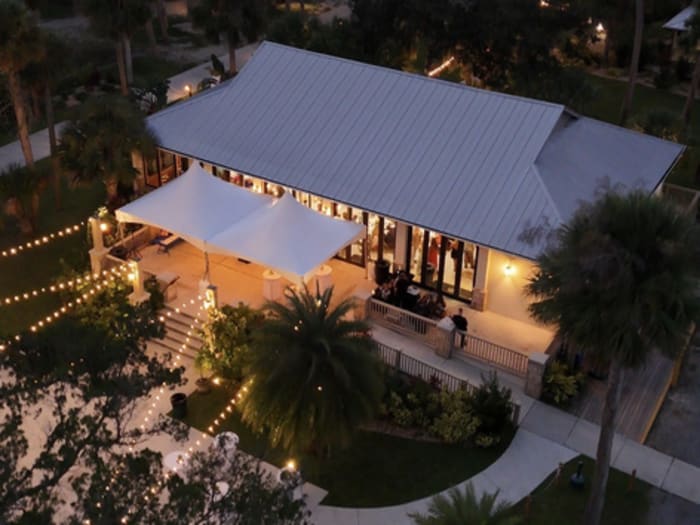 High-angle shot of a building and patio glowing with string lights at night.