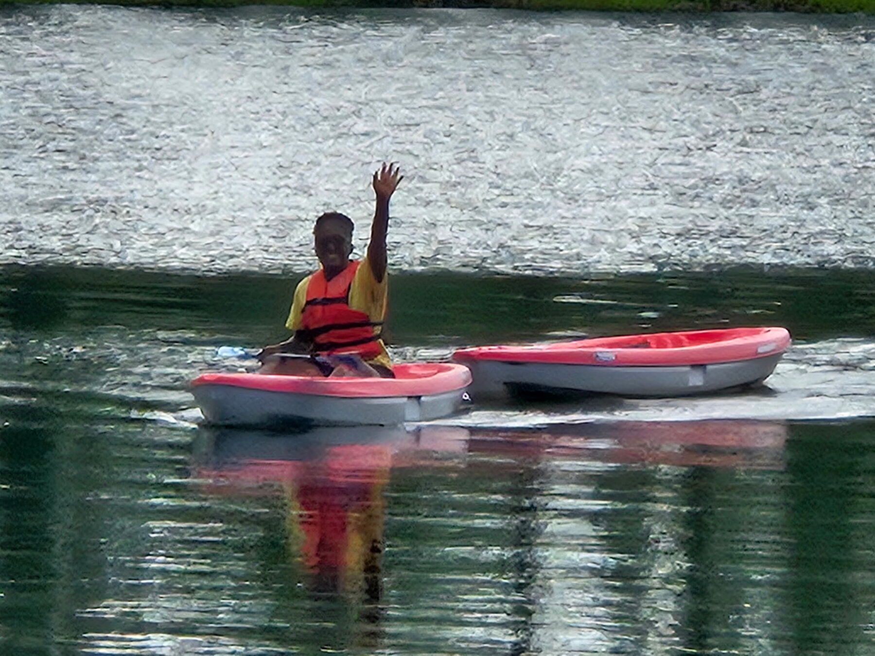 A camper paddling a kayak at McKenzie's Camp Deep Pond